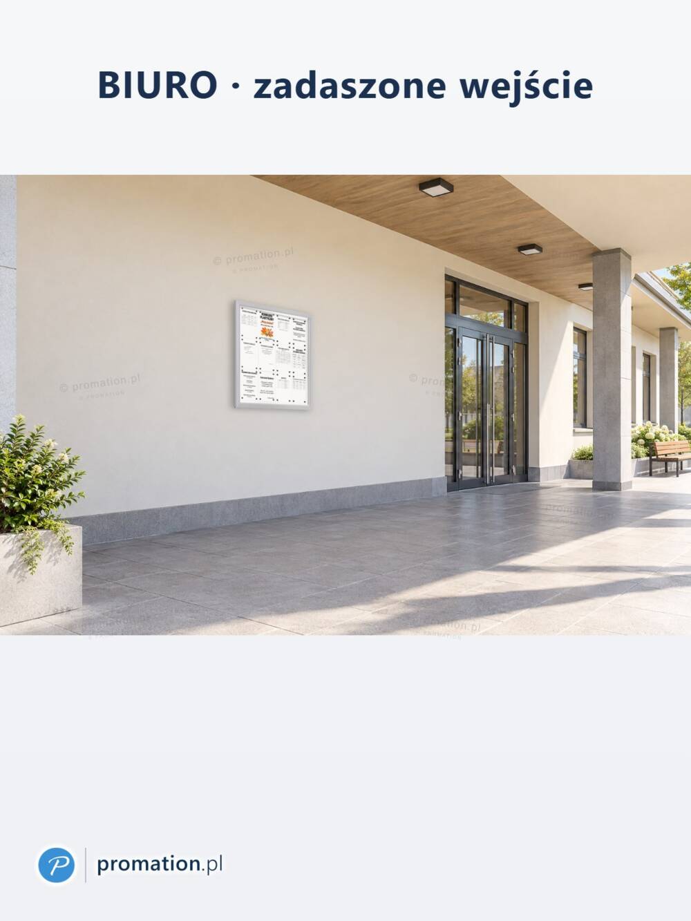 Gablota P406x12 pod zadaszeniem przed biurem, na jasnej ścianie między drzwiami a zielenią