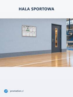 Zamykana gablota korkowa do wnętrz 8×A4 P401x8 na niebieskiej ścianie hali sportowej, obok drzwi z wąską szybą