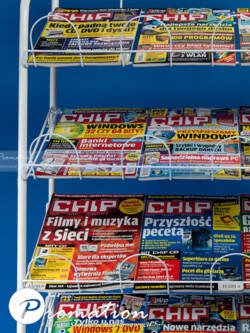 Zbliżenie gazet ułożonych na kilku pochylonych półkach drucianego regału P667