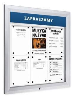 Srebrna gablota zewnętrzna P405Lx6 z sześcioma kartkami A4 za szkłem i przykładowym napisem ZAPRASZAMY na tabliczce u góry, widok pod kątem